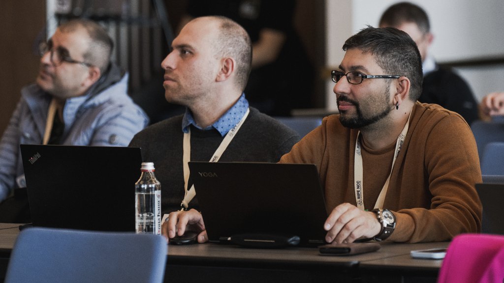 a photo of two men listening to the presentation