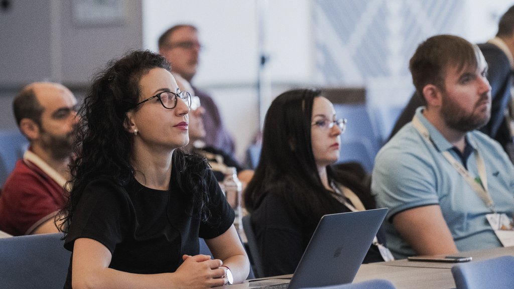 a photo of a woman listening to a presentation